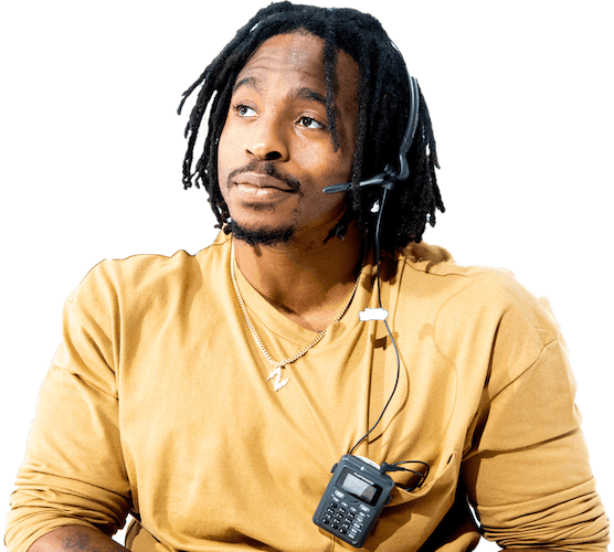 A black man wearing a gold long sleeve shirt wearing a headset and microphone device to communicate with others.
